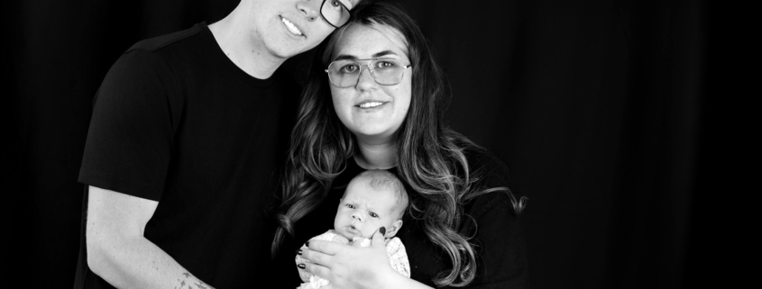 Parents holding their newborn during a professional newborn photoshoot